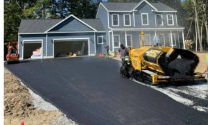 Driveway asphalt installation with paving machine in residential Kingston NY neighborhood
