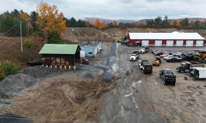 Active asphalt paving job site with trucks and materials in Ravena NY