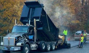 Asphalt paving crew laying blacktop from dump truck in Schenectady NY